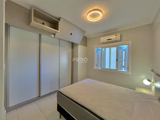 Quarto com cama e armários em um apartamento.
