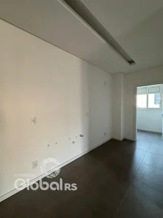 Vista interna de um corredor com paredes brancas e piso escuro.