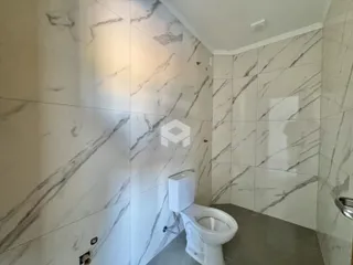 Foto de um banheiro com revestimento de mármore nas paredes.