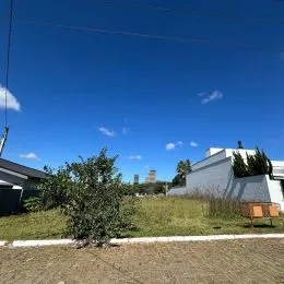 Vista externa de um terreno gramado sob um céu azul claro.