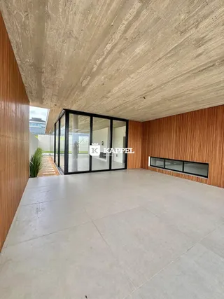 Ambiente interno amplo com piso claro e divisória de vidro.