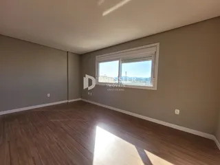 Ambiente interno de uma sala com piso de madeira e grande janela.