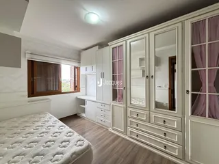 Foto de um quarto com armários embutidos e piso de madeira.