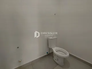 Foto de um banheiro com vaso sanitário branco e paredes brancas.