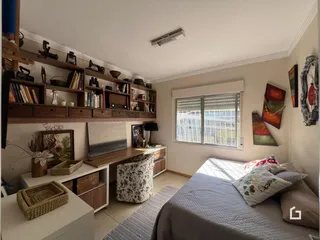 Ambiente interno de uma sala de estar com móveis de madeira e uma cama.