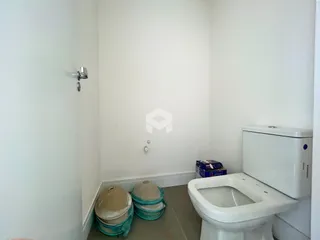Vista interna de um corredor com um vaso sanitário.