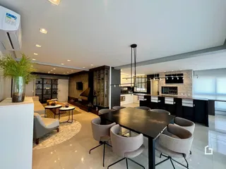 Sala de estar e jantar de um apartamento moderno com cozinha integrada.