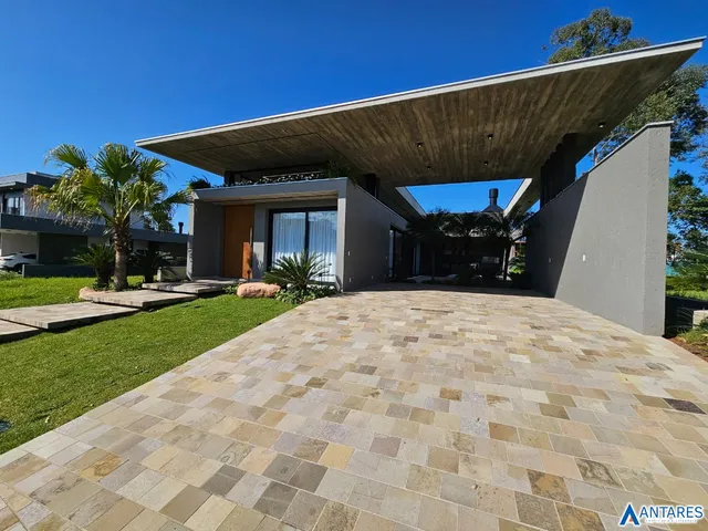A fachada moderna de uma residência em Lajeado, Brasil, com grande área externa pavimentada.