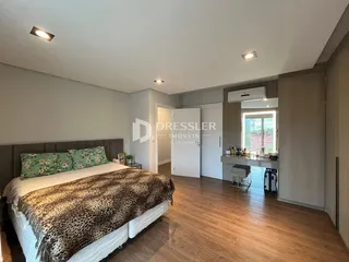 Quarto com cama e piso de madeira no imóvel.