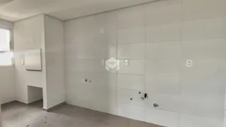 Parede interna com acabamento em concreto e piso de cimento claro.