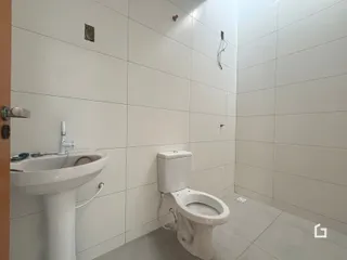 Foto de um banheiro com revestimento branco e piso cinza claro.