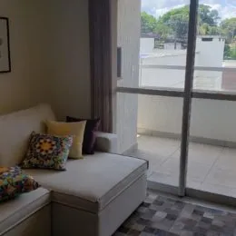 Foto de um interior mostrando uma área com sofá e parede clara em um imóvel.