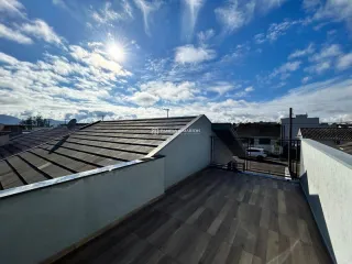 Vista de uma área externa com telhado de telhas brancas em uma propriedade.