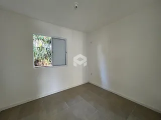Vista interna de um ambiente com paredes brancas e piso claro.