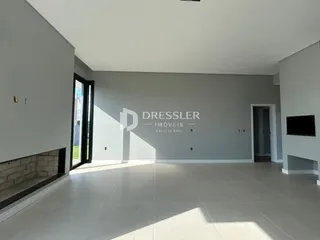 Sala de estar ampla com piso de cerâmica clara em um imóvel em Lajeado.