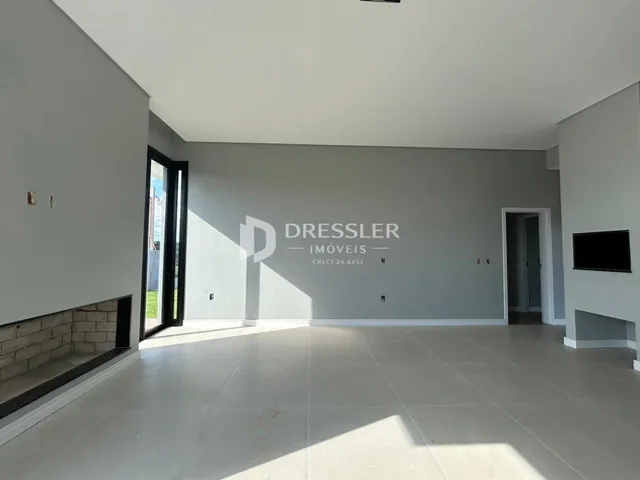 Sala de estar ampla com piso de cerâmica clara em um imóvel em Lajeado.