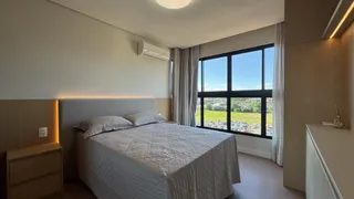 Quarto com cama de casal e janela com vista para o campo.