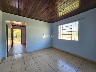 Uma sala com piso de cerâmica e teto de madeira.