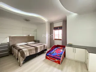 Quarto com cama e janela em ambiente claro.