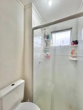 Foto de um banheiro com vaso sanitário e box de vidro.
