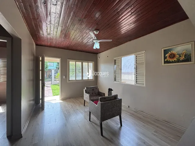 Uma sala de estar com piso de madeira clara e teto de madeira.