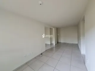Interior de um ambiente com paredes brancas e piso de cerâmica.