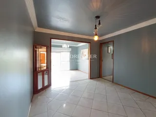 Corredor interno com piso de cerâmica e paredes em tom de azul claro.