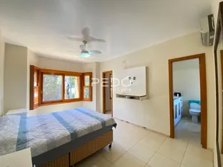Quarto com janela de madeira e porta de madeira em um imóvel no Brasil.