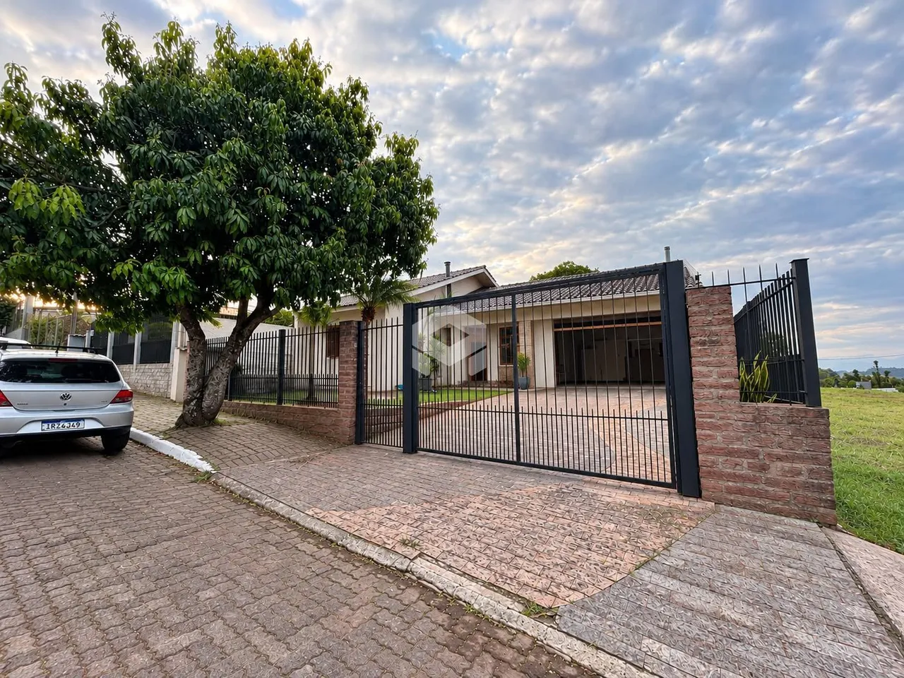 Fachada de uma propriedade com muro de tijolos e portão de ferro na Lajeado.