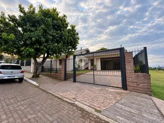 Fachada de uma propriedade com muro de tijolos e portão de ferro na Lajeado.