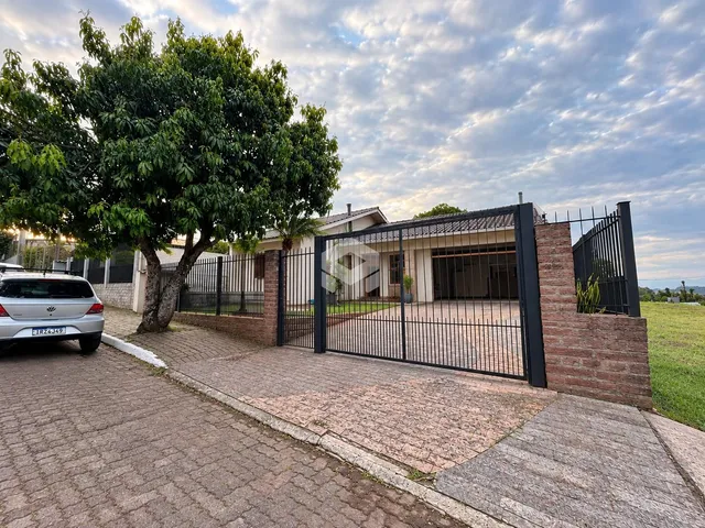 Fachada de uma propriedade com muro de tijolos e portão de ferro na Lajeado.