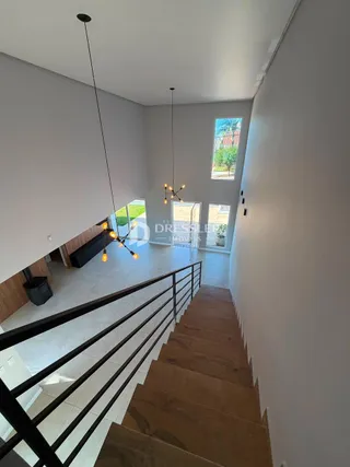 Hall de entrada com escadaria e parede branca em imóvel no Brasil.