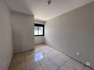 Corredor interno com piso de cerâmica e parede branca.