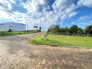 Vista da propriedade com estrada de paralelepípedos e área gramada.