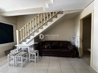Foto de um ambiente interno com escadaria e sofá.
