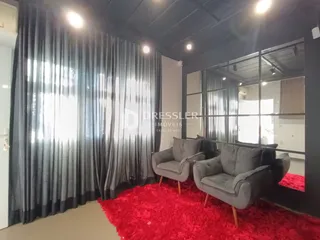 Sala de estar com cortinas escuras e tapete vermelho.