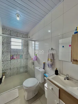 Interior de um banheiro com revestimento de azulejos brancos e pretos.