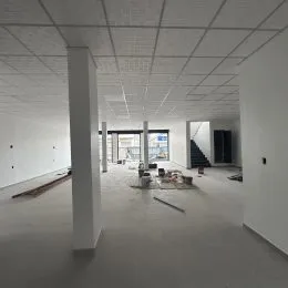 Foto de um ambiente interno com teto suspenso e paredes brancas.