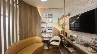 Sala de estar com sofá de couro e parede de tijolos aparentes.