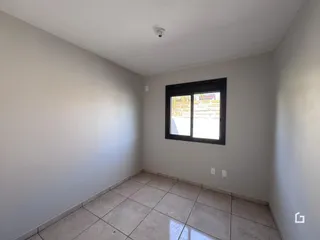 Foto de um cômodo interno com paredes brancas e piso de cerâmica.