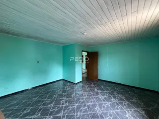 Interior de uma sala com paredes azul-turquesa e piso de cerâmica escura.