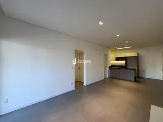 Ambiente interno de uma sala de estar ampla com piso de cerâmica.