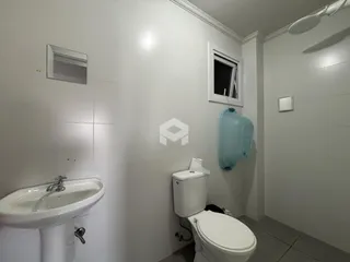 Foto de um banheiro interno com azulejos brancos.
