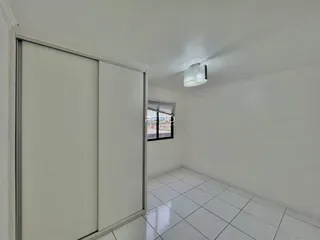 Quarto interno com piso de cerâmica e armário branco.