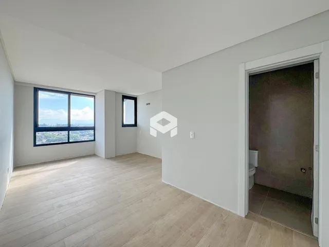 Sala de estar com piso de madeira clara e grande janela.