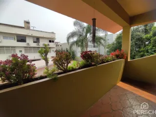 Vista externa de um terraço com vegetação ao fundo.