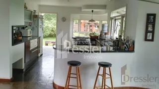 Ambiente interno de uma sala com piso escuro e paredes brancas.