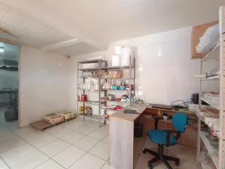 Ambiente interno com paredes brancas e estantes metálicas em Lajeado.