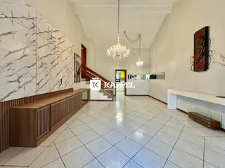 Sala ampla com piso de porcelanato e detalhes em mármore na área de estar.