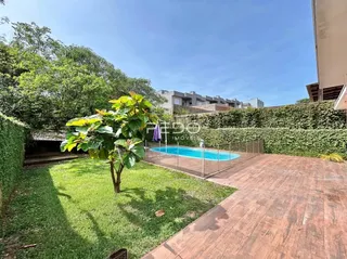 Vista externa do quintal com gramado e piscina.